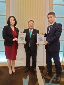 要望書を正面に向けて持つ女性1名と市長を含む男性2名が写った写真