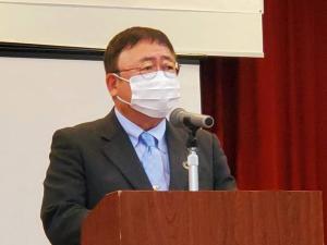 研修会の会場でマイクが設置された檀上に立ち話をしている市長をアップで撮影した写真
