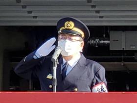 出初式が行われた会場で、制服姿の市長が敬礼をしている写真