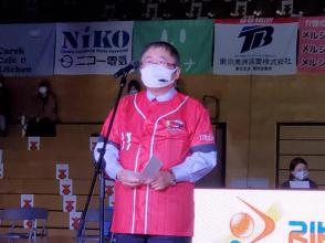 岩手ビッグブルズのユニフォームを着た市長がマイクスタンドの前に立ち話をしている写真