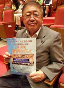 客席に座った市長が演奏会のチラシを持っている写真