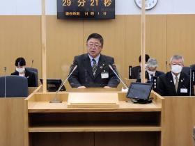 会議場において、市長が演台で質問に回答している写真