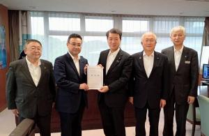 要望書を一緒に持つ男性2人、左端に市長、右端に男性2人が並んでいる写真