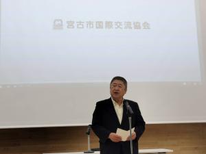 「宮古市国際交流協会」という文字が映し出されたスクリーンの前で、スタンドマイクに向かい話をする様子の市長の写真