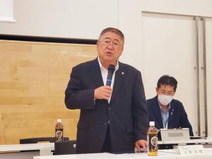 マイクを持って話をするスーツ姿の市長の写真