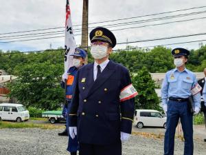 市長が消防の制服を着て、腕章をして立っている写真
