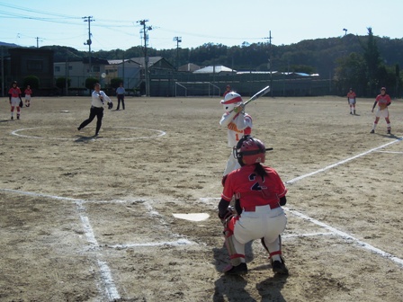 マウンドに立つ市長が、中学生くらいのバッターに向けてボールを投げている写真