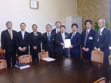 市長と関係者8名が横に並んでおり、市長が要望書を手渡す写真