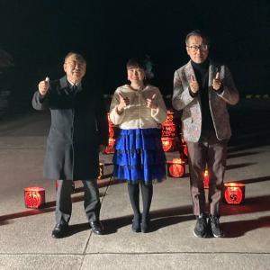 ライトアップされた夜の遊覧船発着所で、演歌歌手の岩崎愛子さんを中心に市長と関係者の男性が親指を上に向けポーズを決めて写っている写真