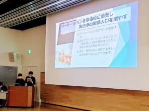 学生の発表の画面が映されたスクリーンを写した写真