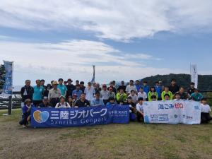 清掃を行った参加者の方々が集合して、前列の方々が「三陸ジオパーク」「海ごみゼロ」と書かれた横断幕を持っている写真