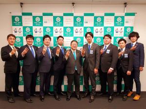 バックパネルの前で市長含めた関係者9名が並んでいる写真