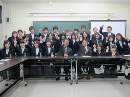 市長と高校生たちが3列に集合しており、全員が拳を握り片手を掲げている写真