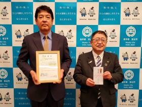 市長が寄付金の目録を持ち、株式会社小林三之助商店の方が市からの感謝状を持ち並んで撮影した写真