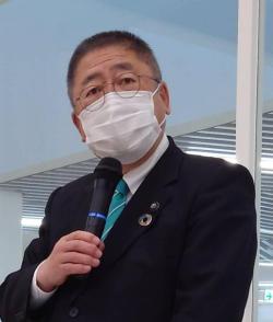 右手にマイクを持ちマスクを着けて斜め前を見据えて話をしている市長の写真
