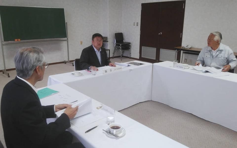 前方に可動式の黒板が設置された株主総会が行われている室内で、市長や関係者が話し合っている様子の写真