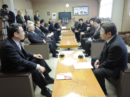長机の両側に向かい合わせに置かれた椅子に座る市長と、関係者の方々の写真