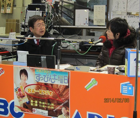 マイクの前で話をする市長とパーソナリティの女性の写真