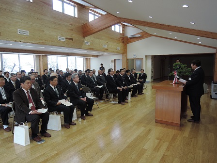 演台のマイクに向かい話をする市長と、演台の向かい側に並べられた椅子に座る大勢の関係者の方々の写真