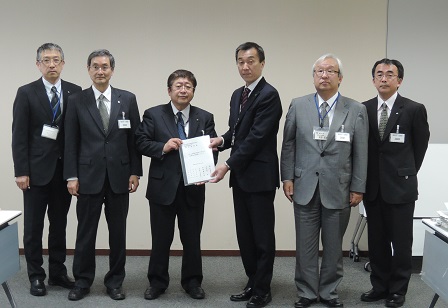要望書を一緒に持つ市長と男性を中心に、4名の男性が横一列に並んでいる記念写真