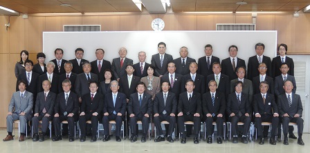 1列目に椅子に座る市長と関係者の方々、2列目、3列目で横並びに立つ関係者の方々の記念写真