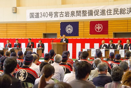 演台に置かれたマイクに向かい話をする市長と、会場の椅子に座る関係者の方々の写真