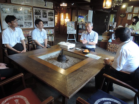 中央に囲炉裏がある机の周りに座る市長と3名の男性の写真