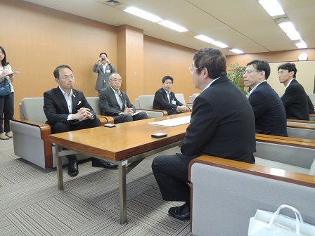 茶色いテーブルの両側に置かれた椅子に座る市長と関係者の方々の写真