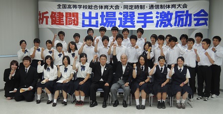 「祈健闘 出場選手激励会」と書かれた横断幕が掲げられた会場で、椅子に座ったり立って並ぶ選手たちと市長の記念写真