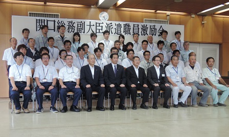 「関口昌一総務副大臣派遣職員激励会」と書かれた紙が貼られたパネルの前で、4列に並んでいる市長や職員の方々の記念写真