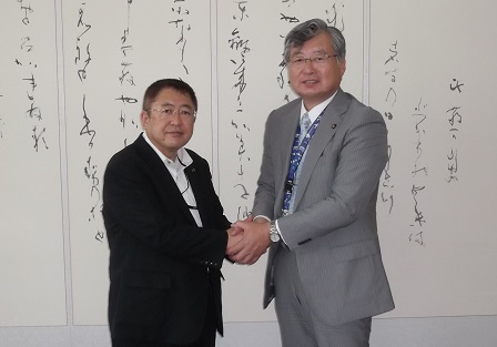 両手で握手をする山本市長と大阪府泉南市の竹中勇人市長の記念写真