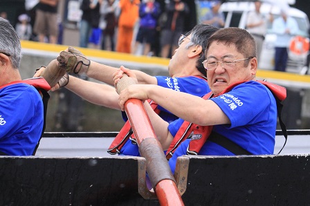 青いTシャツを着てオレンジ色の救命胴衣を身に着けた市長がカッターに乗り櫂を漕ぐ様子の写真