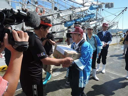 熨斗がついた段ボール箱を受け渡しする様子の男性と青い法被を着た市長の写真