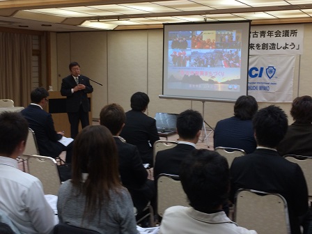 並べられた椅子に座る参加者たちと、スタンドマイクに向かい話をする市長の写真