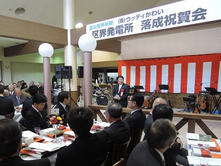 楽器や譜面台が置かれた舞台の前で話す市長と、テーブルに向かい合うように座る関係者の方々の写真
