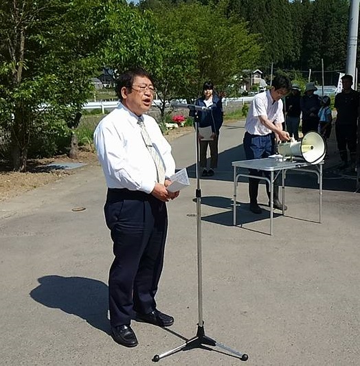 式辞用紙を両手で持ち、スタンドマイクに向かい話をする市長の写真