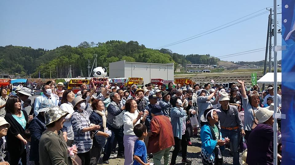大勢の参加者たちが斜め上を見上げている写真