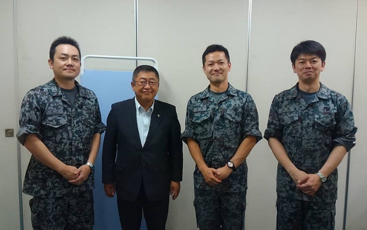 市長と青い迷彩服を着た北部航空音楽隊の隊員3名が並んで立つ記念写真