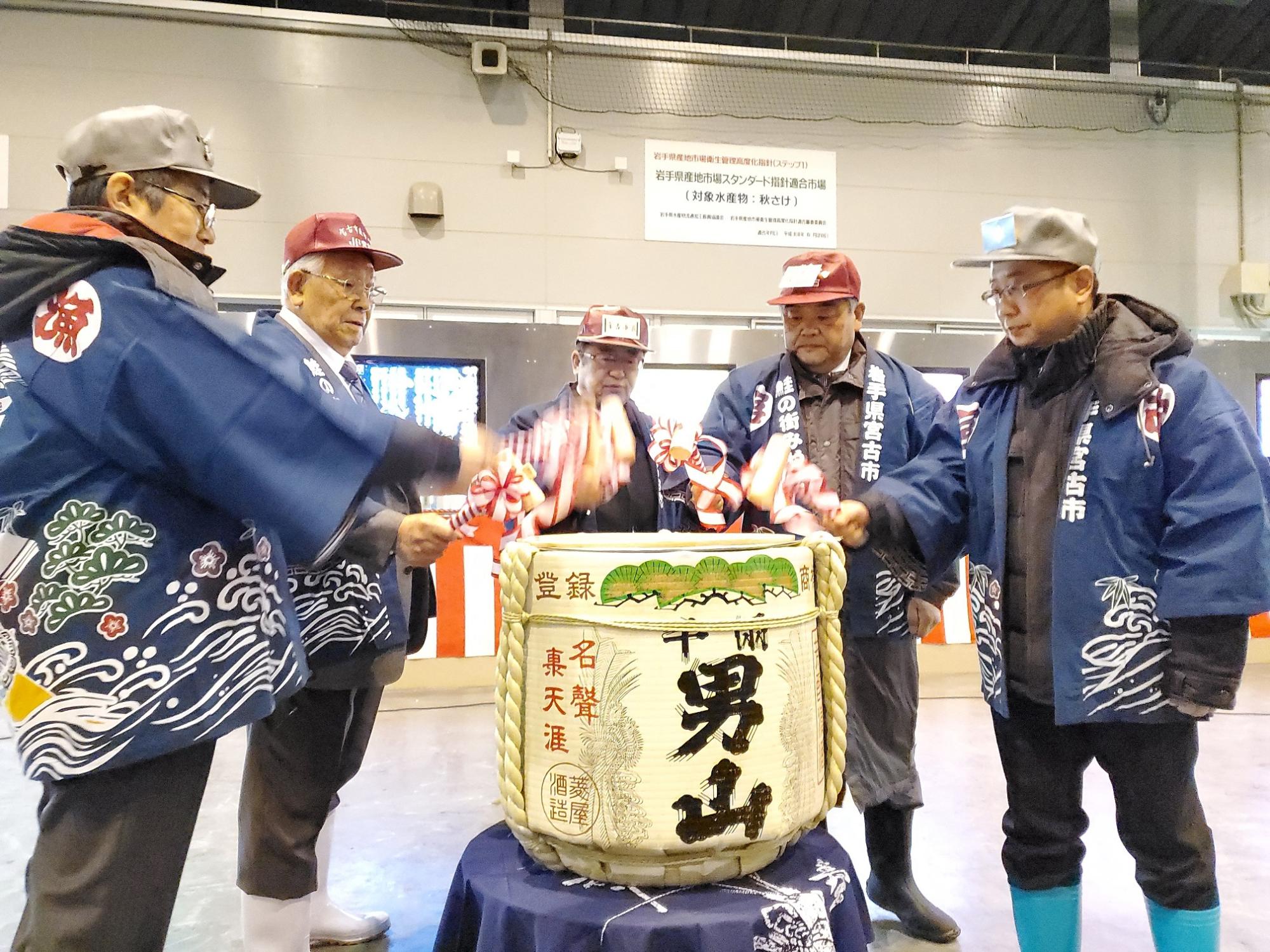 宮古市魚市場内に樽酒が置かれており、法被姿の市長と関係者が木槌を持ち、鏡開きをしている写真