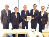 日が差し込んでいる窓側の位置で男性2名で要望書を持ち、その横に市長を含む男性3名が並んで撮影した写真