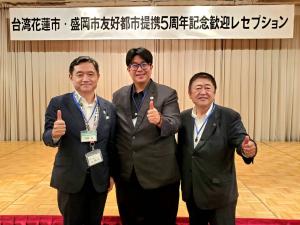 「台湾花蓮市・盛岡市友好都市提携5周年記念歓迎レセプション」と書かれた横断幕の前で市長と男性2名が親指を立てたポーズをして撮影した写真