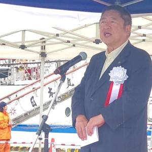 入港した日本丸を背景に白の胸章をつけた市長がスタンドマイクで話をしている写真