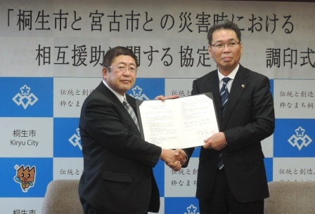 協定書を手に握手を交わす山本宮古市長と亀山桐生市長
