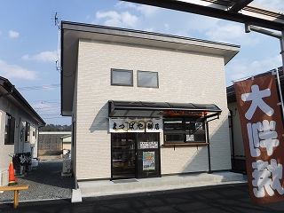 入り口に暖簾が飾られたまつばや餅店の写真