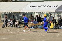 倒れている人（かかし）を担架に乗せて運ぶ参加者