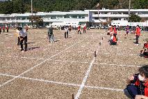 スティックを使ってビール瓶を倒す参加者