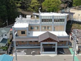外壁にベージュがはいった鉄筋コンクリート造りで入り口が三角屋根をした3階だての田老総合事務所新庁舎の全体を写した写真