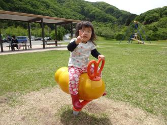 黄色のスイング遊具し座った女の子と男の子ががピースをしている写真