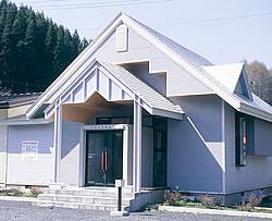 白い外壁の三角屋根の記念館の写真