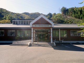 中央入り口の横にスロープが設置された新里診療所を正面から写した写真